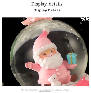 Close-up of a Christmas water globe featuring a pink Santa Claus and a snowman