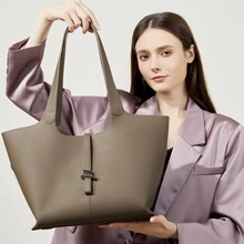 Tragebild einer olivgrünen Leder-Tote-Bag mit Litschi-Muster zu einem lila Anzug