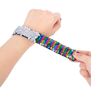 Close-up of sequin slap bracelet showing reversible silver and rainbow scales on wrist