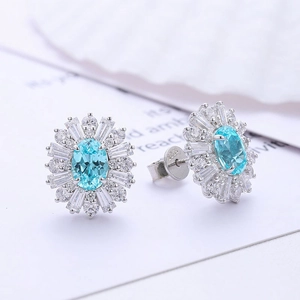 Macro detail of S925 silver sunflower halo earrings with oval blue gemstone