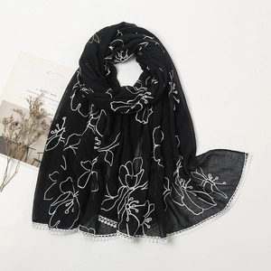 Detail of black cotton linen scarf with white floral embroidery and lace borders