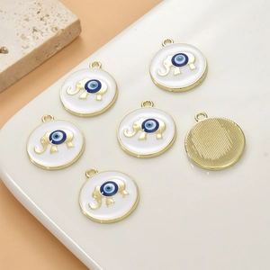 Close-up of alloy evil eye elephant charms with white enamel and golden plating