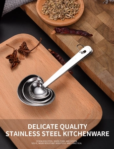 Macro shot of heart-shaped stainless steel measuring spoons with engraved motivational phrases