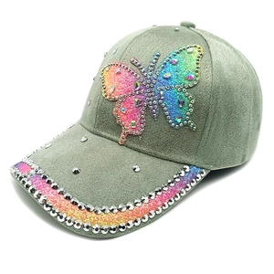 Detail of suede baseball cap with colorful rhinestone butterfly and studded brim