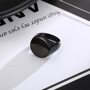Macro shot of minimalist black oval signet ring with smooth polished stainless steel finish