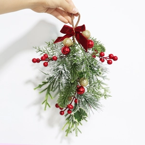 Christmas teardrop swag with red berries pine branches and velvet bow hanging on white background