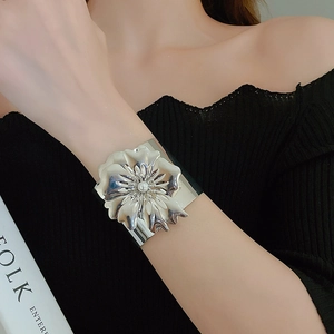 Detail of silver oversized flower cuff bracelet with a pearl accent on the model's wrist