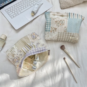 Detailed shot of quilted lace floral makeup bags showing large zipper closure and soft texture