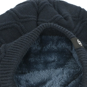 Close-up of deep blue knitted beanie showing diamond pattern and thick fleece lining