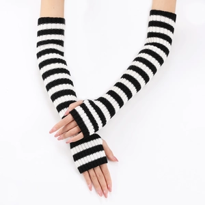 Detail of black and white striped knitted arm warmers on model against white backdrop