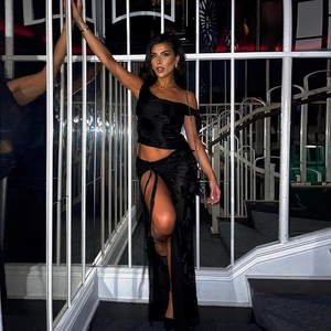 Two-piece black sheer set with one-shoulder crop top and high-slit floral textured skirt