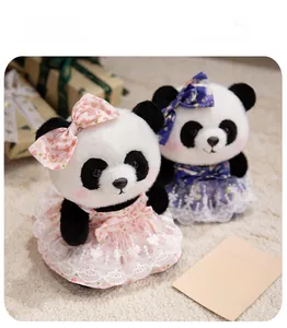 Close-up of cute panda plush toys in pink and blue lace dresses on soft carpet