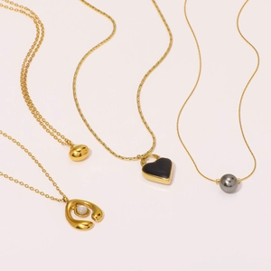 French luxury gold stainless steel necklaces with heart pendants and pearls on white background