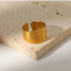 Detailed macro shot of a wide gold hammered texture stainless steel open ring