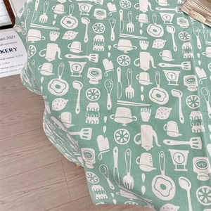 Detailed fabric texture of bean green cotton linen tablecloth with white hand-drawn kitchen patterns