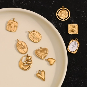 Detail of vintage 18K gold plated charms with floral and angel relief designs
