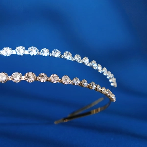 Elegant gold and silver rhinestone headbands on dark blue fabric, close-up luxury hair accessory