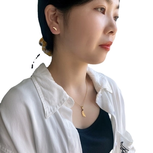 Elegant gold leaf pendant necklace and stud earrings set for women on model