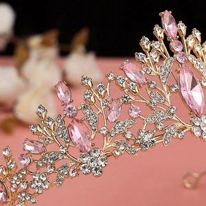 Close-up of golden crown with pink marquise crystals and sparkling white rhinestones