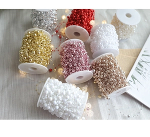 Detail of colorful pearl beads on spools for Christmas decoration and DIY crafts