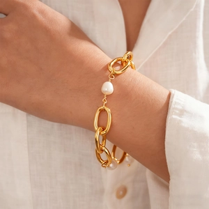 Close-up of 18k gold plated chunky chain bracelet with pearl on a woman's wrist