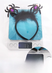 Detail shot of Halloween spider headband on a scale weighing 17.8g with purple rhinestones