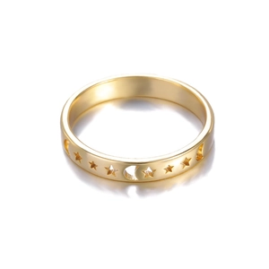 Close-up of golden ring featuring hollowed-out star and moon celestial patterns