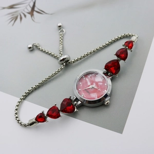 Detail of silver ladies bracelet watch with red heart crystals and pink marble dial