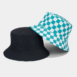 Detail view of double-sided bucket hats in solid black and green-white checkerboard patterns