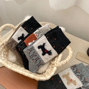 Close-up of thick wool socks with cute dog patterns and bone textures in a basket