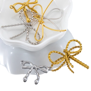 Detailed view of gold and silver butterfly pendants with twisted metal textures for DIY jewelry