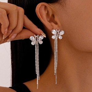 Silver butterfly tassel earrings with sparkling rhinestones worn by a model