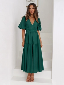 Detail of dark green maxi dress featuring deep V-neckline and layered puff sleeve design