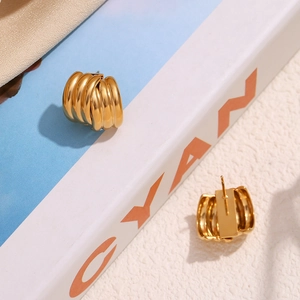 Detail of 18K gold-plated stainless steel stud earrings with triple-layered ribbed design