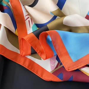 Close-up of a satin square scarf with abstract geometric patterns and silky sheen
