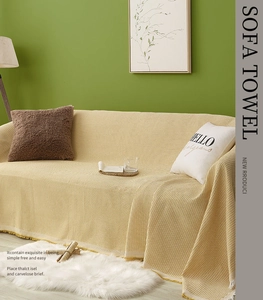 Detail of yellow waffle weave sofa cover featuring fringe edges in a cozy living room