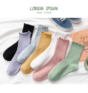 Detail showing colorful mid-calf socks with elegant ruffle edges and ribbed cotton texture