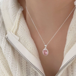 Detail view of 925 silver necklace with pink zircon pendant on white knit sweater