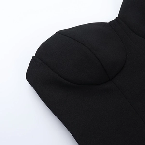 Detailed macro view of the structured cup design and woven texture on a black tube dress