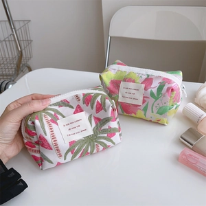 Detail view of jacquard floral and geometric pattern makeup bags with zipper closure