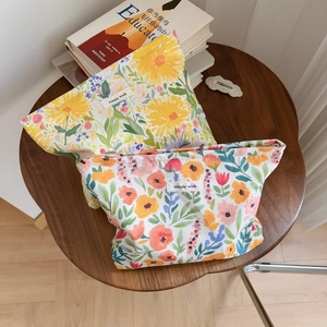 Close-up of floral print cotton makeup bags with simple wish labels on a wooden table