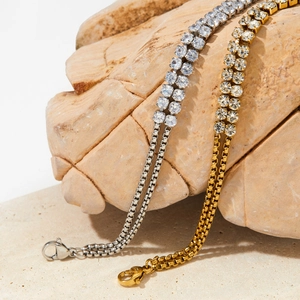 Detailaufnahme von zweireihigen Strass-Tennisarmbändern auf Stein mit Karabinerverschluss