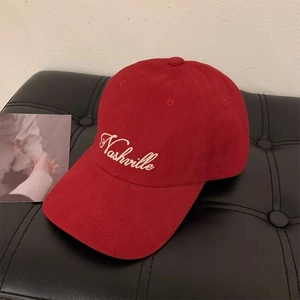 Detail of a dark red cotton baseball cap with Nashville embroidery on quilted leather