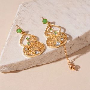Detail of Chinese gourd earrings with green beads and asymmetrical gold chain tassels