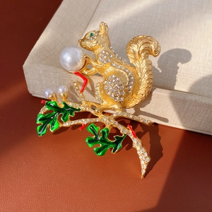 Vue détaillée d'une broche écureuil vintage avec cristaux blancs, perles et émail vert