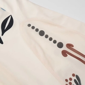 Close-up of beige mesh fabric with intricate black and brown geometric patterns