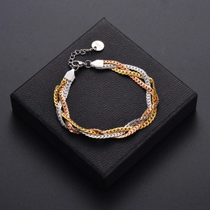 Three-tone braided stainless steel chain bracelet in gold, silver, and rose gold on jewelry box
