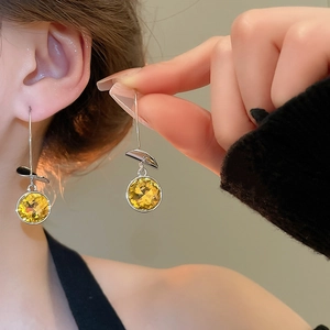 Close-up of yellow round faceted crystal drop earrings with elegant silver hooks