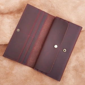 Macro detail of wine red crazy horse leather wallet showing card slots and hand stitching