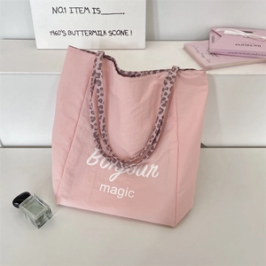 Pink tote bag detail with Bonjour magic text and stylish leopard print shoulder straps
